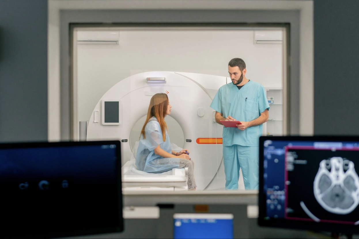 MRI technician discusses scan procedure with patient, highlighting healthcare technology solutions in a modern imaging suite